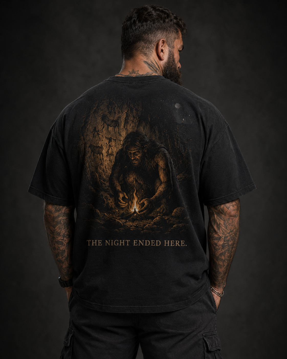 Person wearing a black t-shirt with a graphic design and text on the back against a dark background
