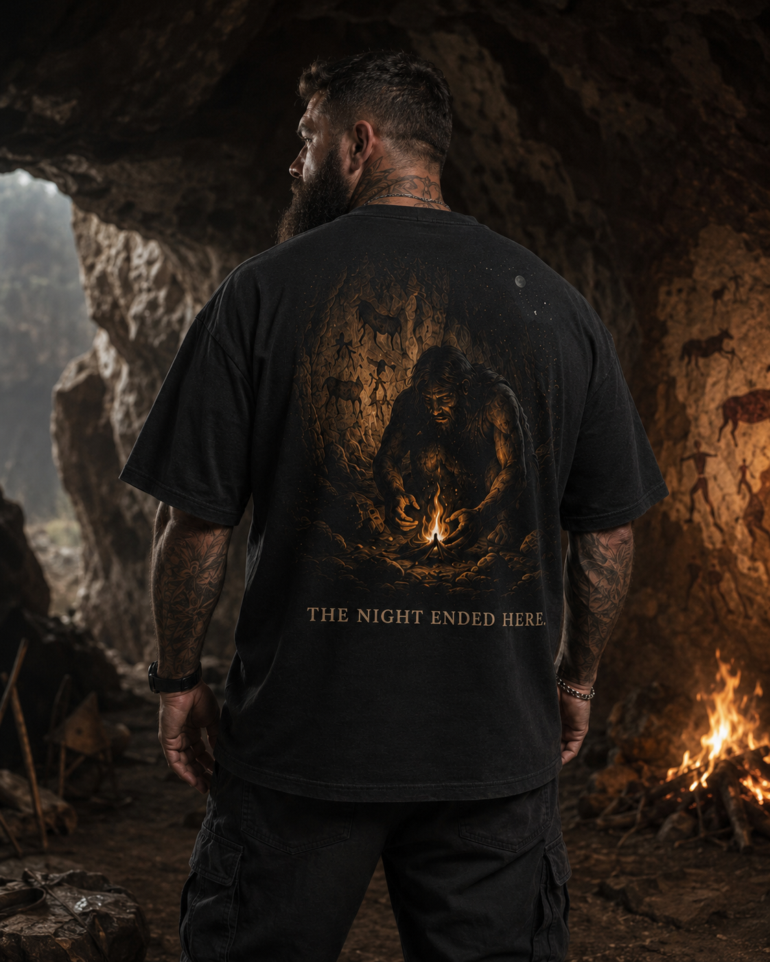 Man wearing a black t-shirt with a bear graphic and text in a cave setting